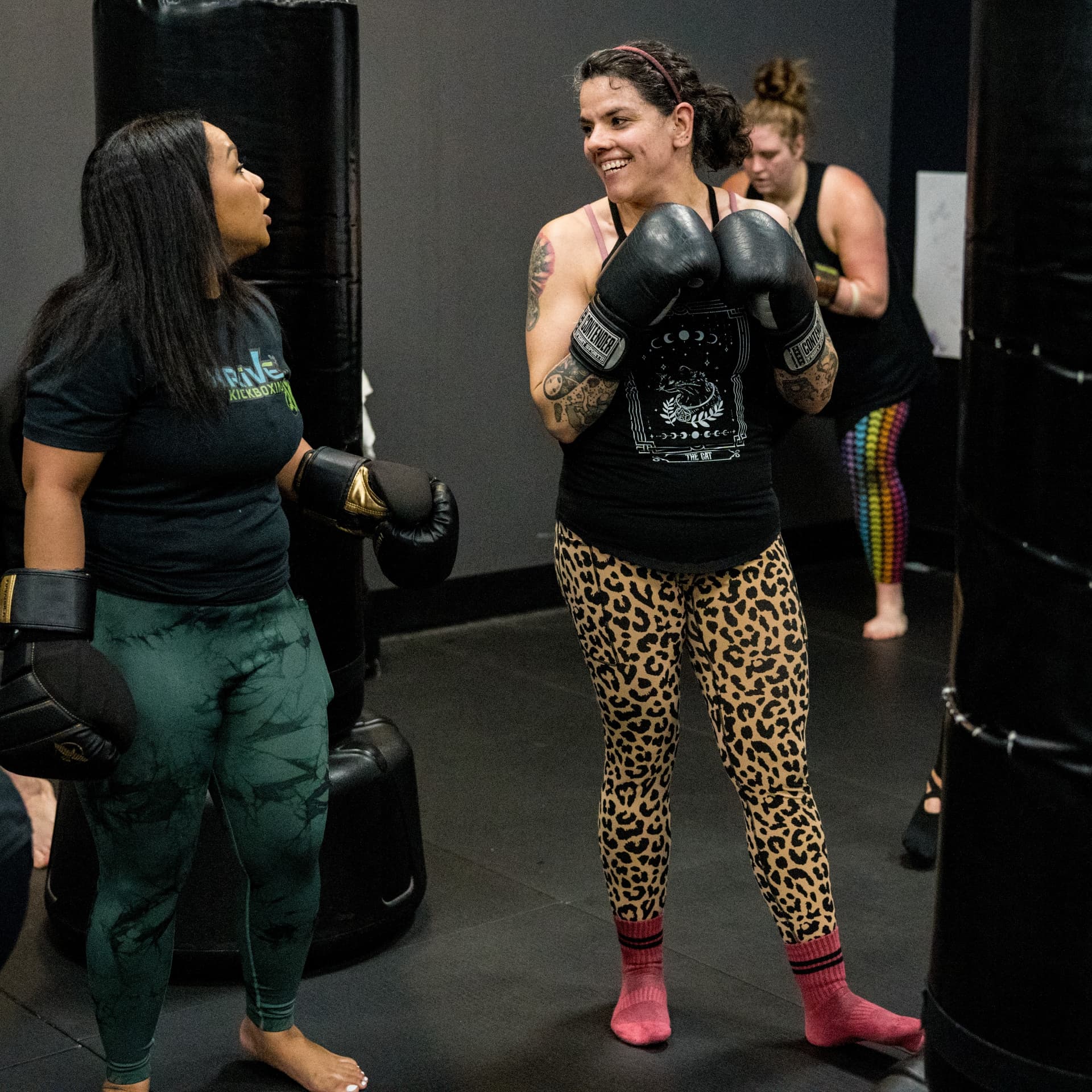 Thrive Kickboxing coach talking with a member between rounds on the gym floor
