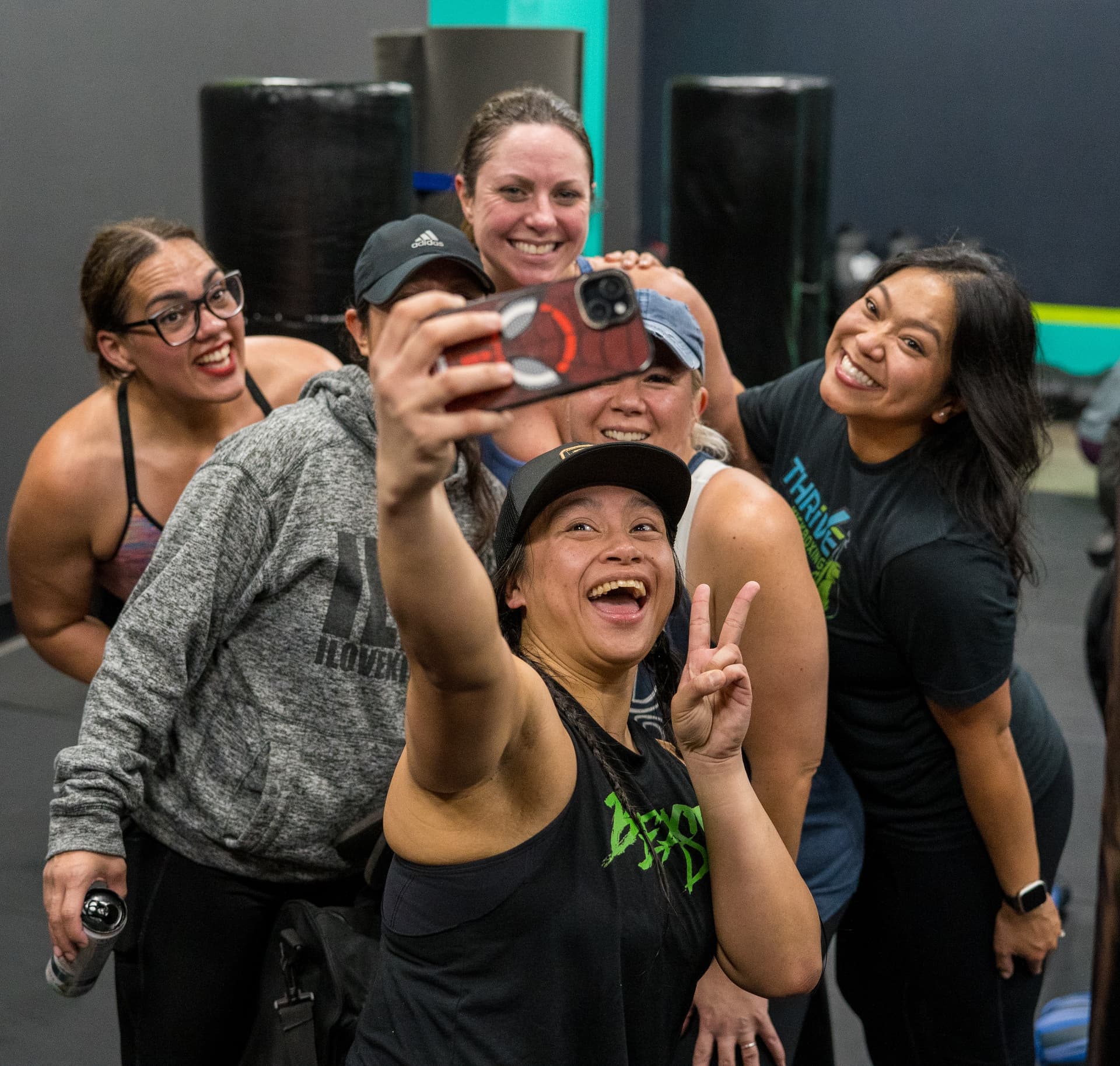Group of Thrive Kickboxing members laughing during a post-class selfie